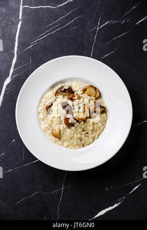 Risotto con funghi porcini su piastra in marmo scuro sfondo tabella spazio di copia Foto Stock