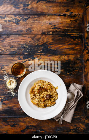 Risotto con funghi porcini su piastra su tavola di legno sfondo spazio di copia Foto Stock