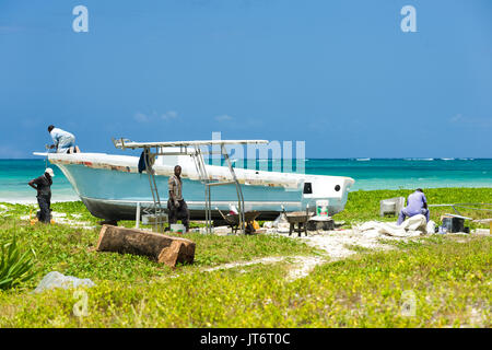 Edificio locale vetroresina barca da pesca dalla spiaggia, Diani, Kenya Foto Stock