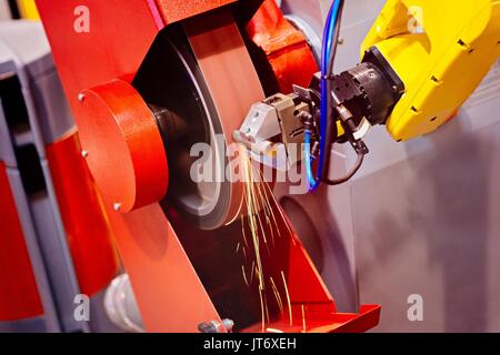 Automatico della macchina di molatura nella fabbrica di grind un pezzo di metallo con la formazione di scintille Foto Stock