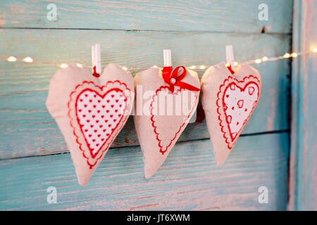 Cuori di tessili sul vecchio turchese rustico in legno sfondo. Il giorno di San Valentino Foto Stock