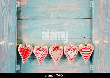 Cuori di tessili sul vecchio turchese rustico in legno sfondo. Il giorno di San Valentino Foto Stock