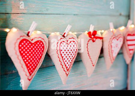 Cuori di tessili sul vecchio turchese rustico in legno sfondo. Il giorno di San Valentino Foto Stock