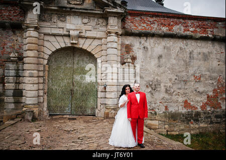 Incredibile sposi in posa vicino alle antiche porte di un castello. Foto Stock