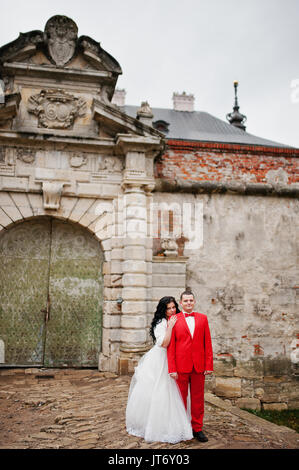 Incredibile sposi in posa vicino alle antiche porte di un castello. Foto Stock