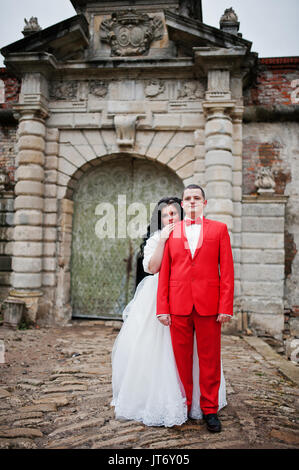 Incredibile sposi in posa vicino alle antiche porte di un castello. Foto Stock