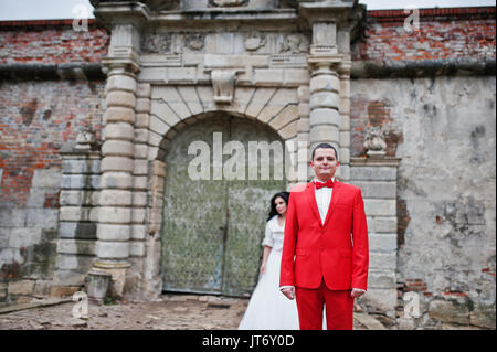 Incredibile sposi in posa vicino alle antiche porte di un castello. Foto Stock