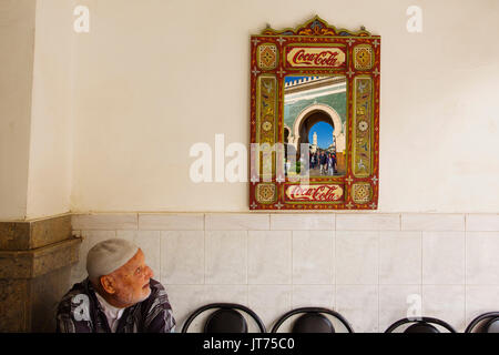 La vita di strada scena. Bab Bou Jeloud gate riflessa in uno specchio, entrata principale souk Medina di Fez, Fes el Bali. Il Marocco, Maghreb Nord Africa Foto Stock