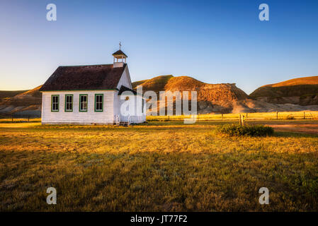 In estate il tramonto del vecchio pioniere in legno chiesa nella città fantasma di Dorothy in Alberta, Canada. Foto Stock