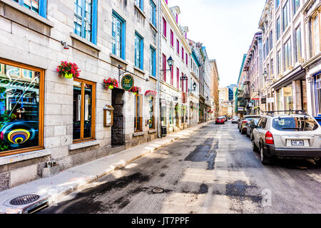 Montreal, Canada - 28 Maggio 2017: la zona della città vecchia con il ristorante di segno e colore rosso geranio vaso di fiori appesi per strada durante il giorno al di fuori nella regione di Québec Foto Stock