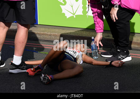 Monika Athare dell India è crollato dopo aver attraversato la linea del traguardo al termine della IAAF Campionati del Mondo 2017 Marathon race in Londra, Regno Unito. Foto Stock