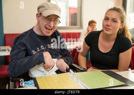 Würzburg, Germania. 28 Luglio, 2017. Hagen, membro del servizio dating 'Herzenssache' (lit. questione di cuore), prende parte a una riunione del servizio di dating in Würzburg, Germania, 28 luglio 2017. Accanto a lui si siede il suo caregiver Susanne. Se le persone disabili di registrarsi presso un servizio di dating rimangono spesso sfortunato. Il servizio dating 'Herzenssache' prefissa il compito di riunire le persone con handicap. Foto: Daniel Karmann/dpa/Alamy Live News Foto Stock