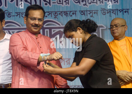 Kolkata, India. 07 Ago, 2017. Nuotatore Sayani Das (destra) legami Rakhi o filetto sacred al Ministro di Stato Aroop Biswas (sinistra) durante la Sanskriti Diwas in occasione di Raksha Bandhan festival in Kolkata. Il Bengala Occidentale di governo dello sport e della gioventù dipartimento servizi organizzati Sanskriti Diwas per armonia e solidarietà in occasione di Raksha Bandhan festival il 7 agosto 2017 in Kolkata. Credito: Saikat Paolo/Pacific Press/Alamy Live News Foto Stock