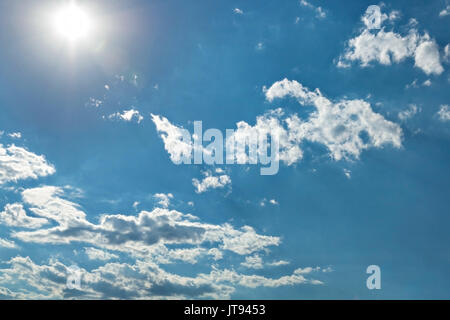 Sole brillante, heap bianche nuvole e sole brillante nel cielo blu Foto Stock