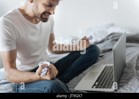Pezzo di carta sminuzzata in un mans mano Foto Stock