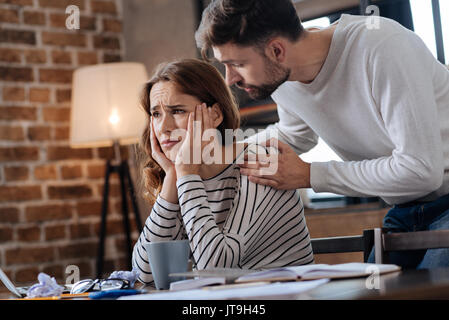 Cupa bella donna che mantiene il suo mento Foto Stock