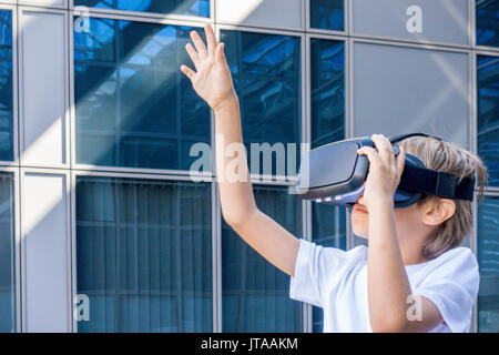 Ragazzo con la realtà virtuale gli occhiali di protezione in città Foto Stock