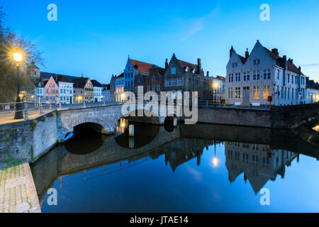 Le luci del tramonto su edifici storici del centro città si riflette nei tipici canali di Bruges, Fiandre Occidentali, Belgio, Europa Foto Stock