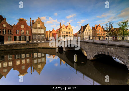 Prime luci dell alba su edifici storici e il ponte si riflette in un tipico canale di Bruges, Fiandre Occidentali, Belgio, Europa Foto Stock