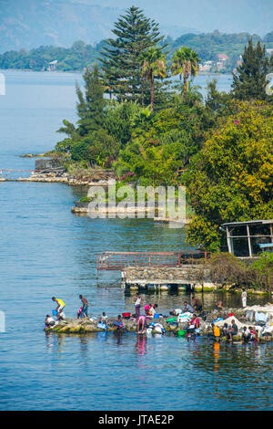 Le donne lavare i loro vestiti sulle rive del lago Kivu, Goma, nella Repubblica democratica del Congo, Africa Foto Stock
