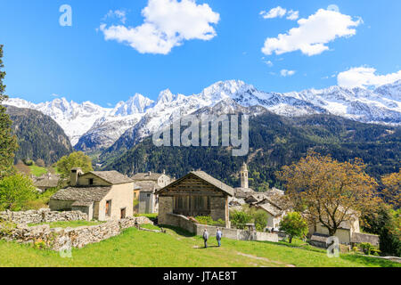 Vista del Soglio tra prati e vette innevate in primavera, Maloja, Val Bregaglia, Engadina nel cantone dei Grigioni, Svizzera, Europa Foto Stock