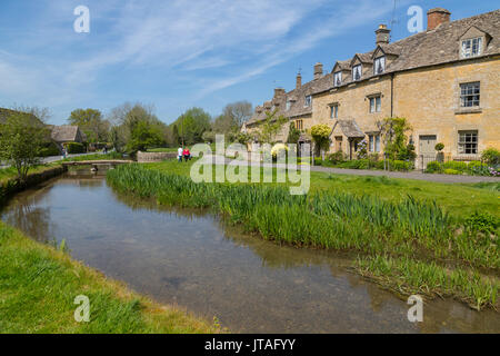 Cottages e passerella sul fiume occhio in Lower Slaughter, Cotswolds, Gloucestershire, England, Regno Unito, Europa Foto Stock