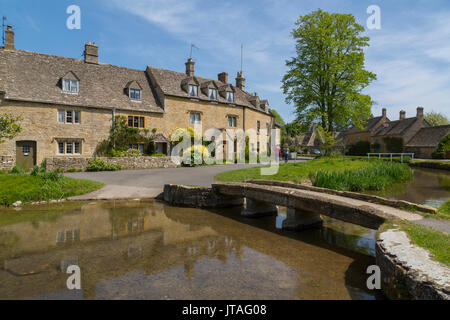 Cottages e passerella sul fiume occhio in Lower Slaughter, Cotswolds, Gloucestershire, England, Regno Unito, Europa Foto Stock