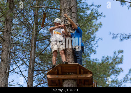 MEZIO, Portogallo - 22 luglio 2017: uomo avventuroso si prepara a una diapositiva in zip fodera attraverso la foresta. Luglio 22, 2017, Mezio, Portogallo. Foto Stock