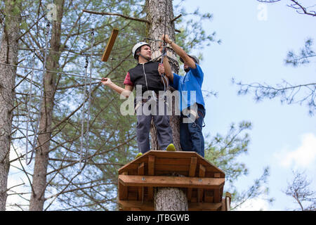 MEZIO, Portogallo - 22 luglio 2017: uomo avventuroso si prepara a una diapositiva in zip fodera attraverso la foresta. Luglio 22, 2017, Mezio, Portogallo. Foto Stock