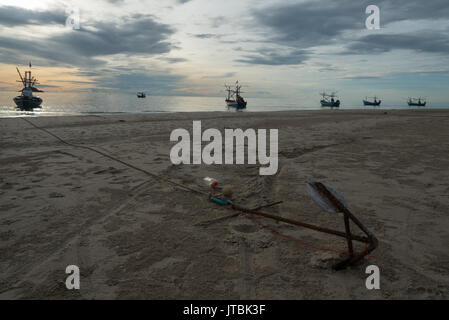 Barche da pesca ormeggiate sulla spiaggia di Hua Hin all'alba Foto Stock