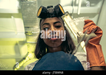 Ragazza giovane tecnico di laboratorio in equipaggiamento protettivo personale, laboratorio chimico Foto Stock