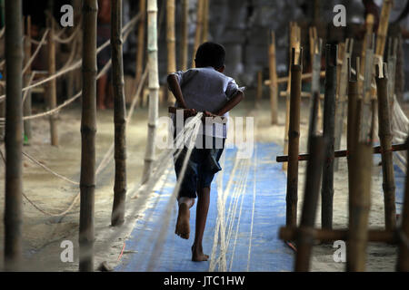 Bambino fatiche lavorando in una corda manufacturing factory a Keraniganj a Dhaka il 09 giugno 2013. Foto Stock