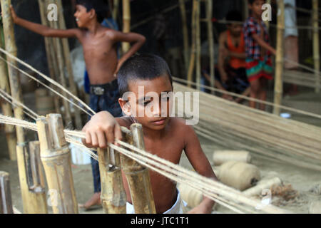 Bambino fatiche lavorando in una corda manufacturing factory a Keraniganj a Dhaka il 09 giugno 2013. Foto Stock