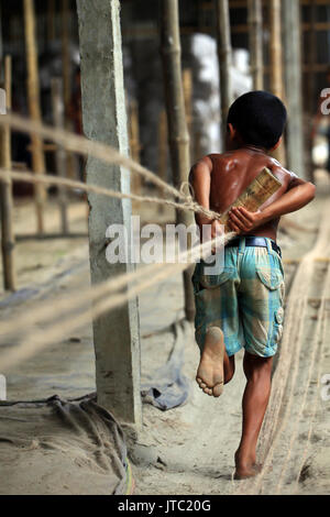 Bambino fatiche lavorando in una corda manufacturing factory a Keraniganj a Dhaka il 09 giugno 2013. Foto Stock