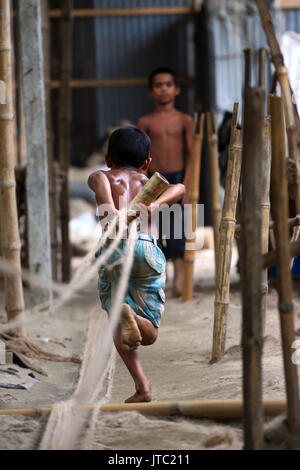 Bambino fatiche lavorando in una corda manufacturing factory a Keraniganj a Dhaka il 09 giugno 2013. Foto Stock