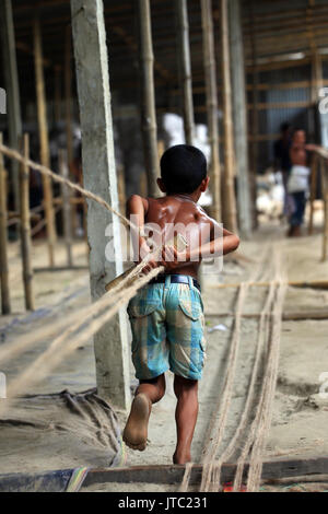 Bambino fatiche lavorando in una corda manufacturing factory a Keraniganj a Dhaka il 09 giugno 2013. Foto Stock