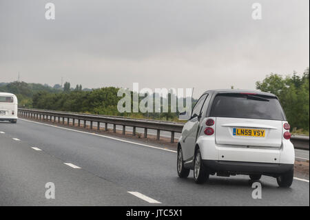 Una Smart auto guidando su una strada principale nel Regno Unito Foto Stock