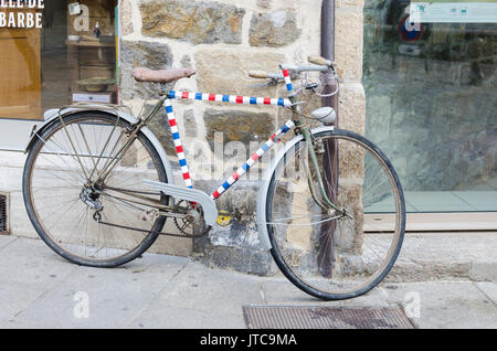 Vintage bicicletta appoggiata contro una parete a Dinan in Bretagna, Francia Foto Stock