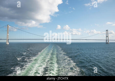 Attraversando il ponte di sospensione Grande Belt Danimarca collegamento della Zelanda e Funen con una barca Foto Stock