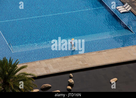 L'uomo la pulizia piscina scoperta in un hotel tropicale Foto Stock