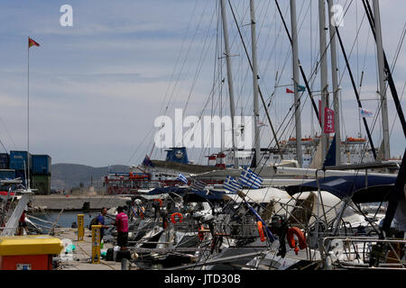 Lavrio Port Attica Grecia Yachts con bandiere Greca uomini parlando sul molo Foto Stock