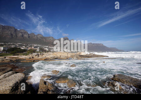 Onde infrangersi lungo il litorale di Camps Bay nella parte anteriore dei dodici Apostoli mountain range in Città del Capo Western Cape, Sud Africa. Foto Stock