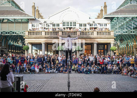 Un escapologist unicyclist eseguendo per la folla in Covent Garden di Londra. Da una serie di quadri di artisti di strada a Londra, Regno Unito. Data foto: Foto Stock