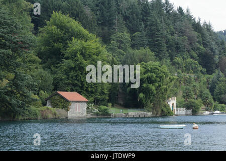 Una casa con alberi accanto al lago d'Orta shore in provincia di Novara, Italia settentrionale, con una barca Foto Stock