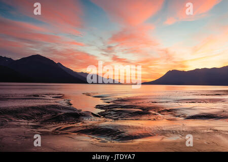 Alpenglow oltre il Chugach e Kenai Mountains e le piane di marea del braccio Turnagain centromeridionale in Alaska. Foto Stock