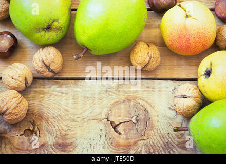 In autunno la composizione di frutta e spezie - pere e noci, foglie di acero su uno sfondo di legno tonificante Foto Stock