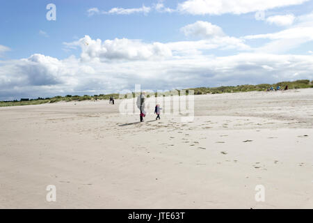 Scozia, Highlands, Nairn, People Walking on the Beach, impronte nella sabbia, Grass Area, Scottish Landscape, Beach, Blue Skies, Nuvole bianche Foto Stock