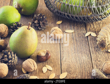 In autunno la composizione di frutta e spezie - pere e noci su uno sfondo di legno tonificante Foto Stock
