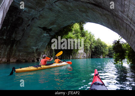 Madre e figlio kayak sotto un ponte su un bellissimo fiume turchese Soca, Most na Soci, Slovenia. Foto Stock