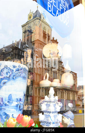 La Stadhuis riflessa nella vetrina di un negozio di ceramica blu di Delft shop in Delft, South Holland, Paesi Bassi Foto Stock